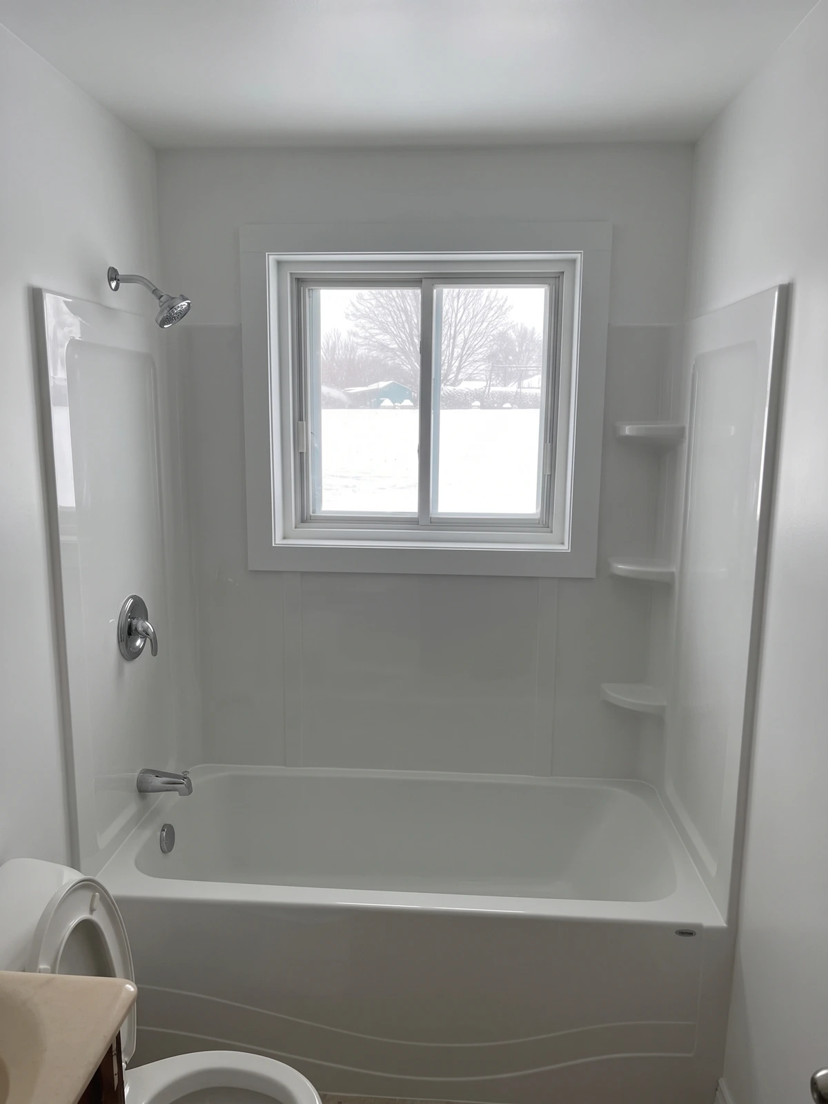 La même salle de bain après la rénovation, bain neuf et contour blanc